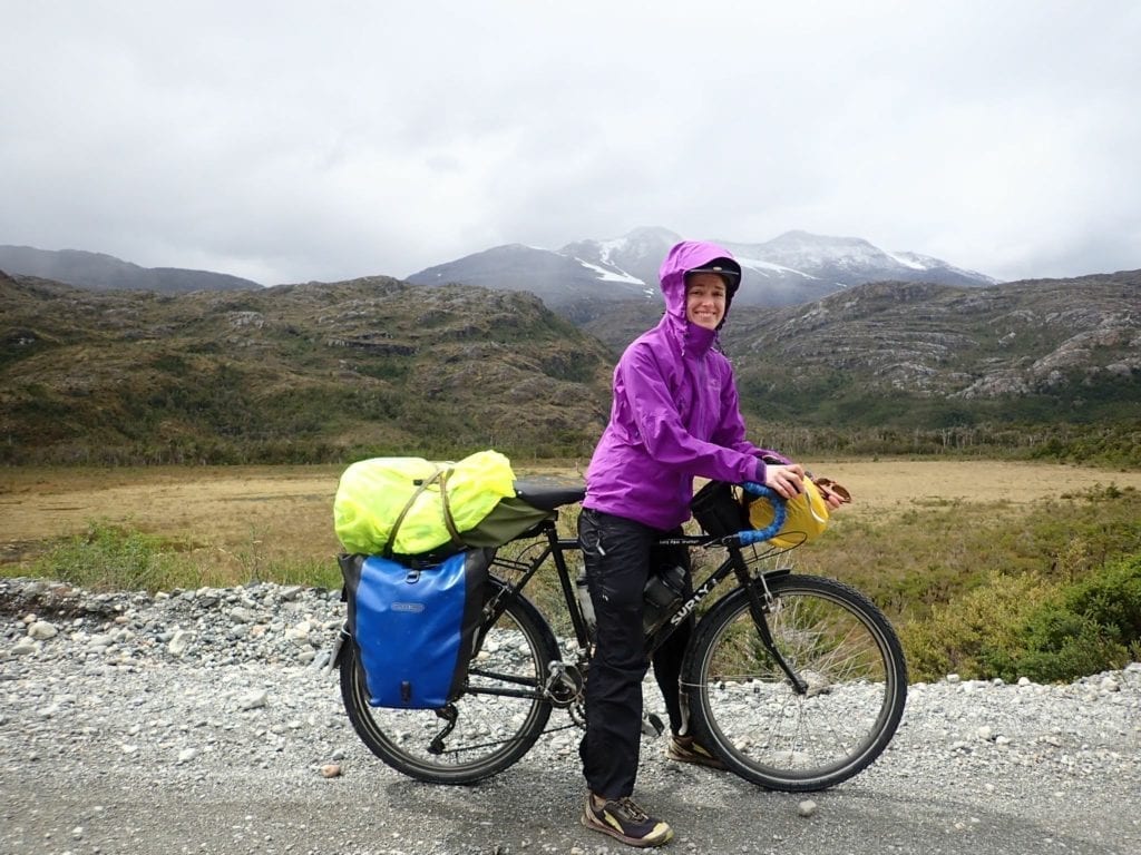 Touring cyclist in purple rain jacket on Carretera Austral