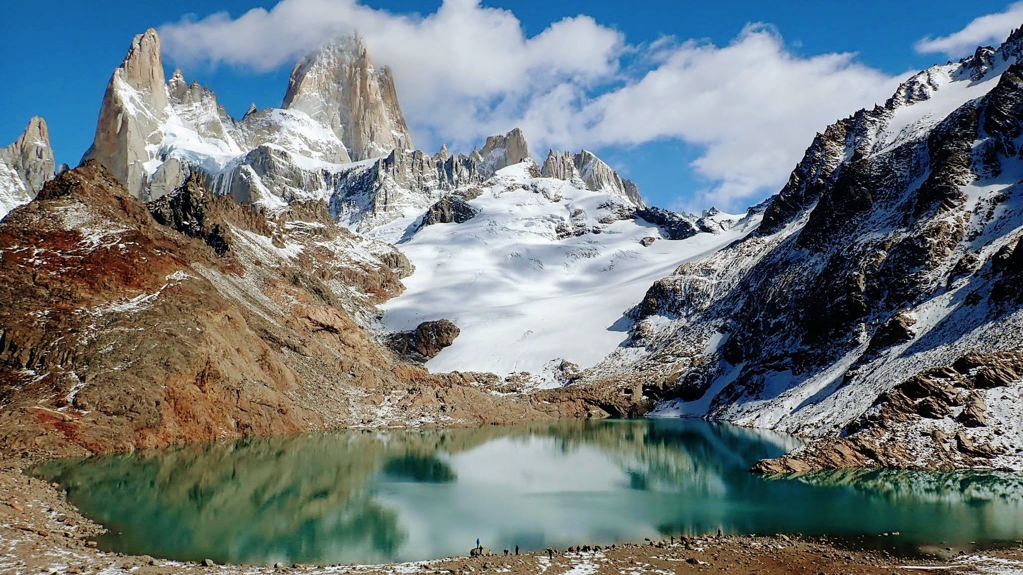 Rocky mountain spires with glacier and bright blue alpine lake