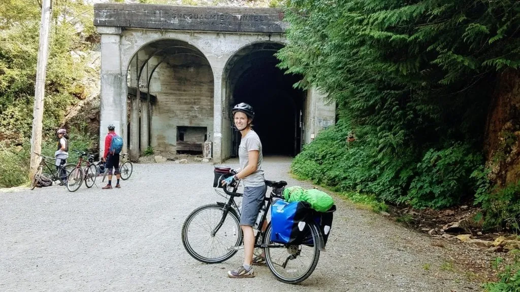 Touring cyclist in front of old railway tunnel on the Palouse to Cascades Trail