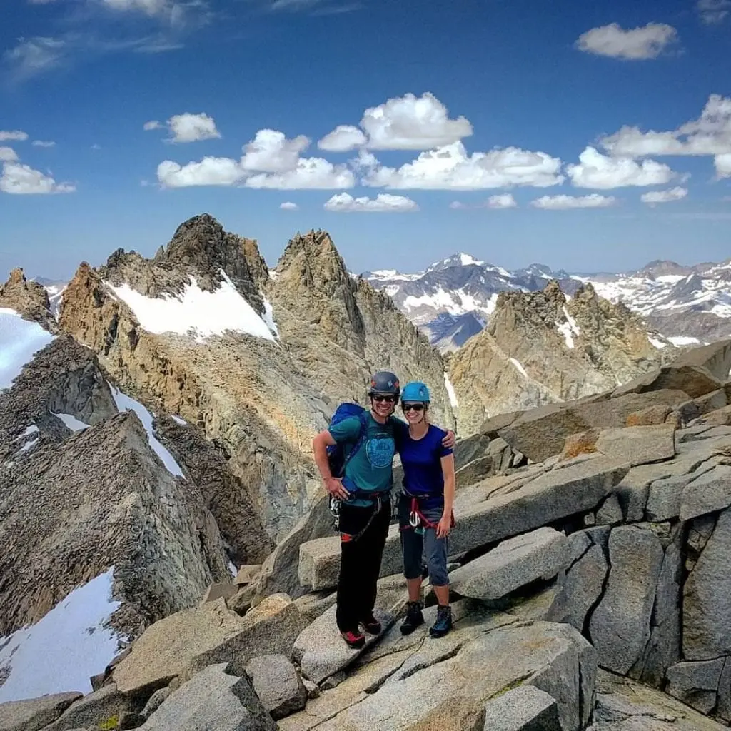 Couple of climbers at summit of Sill with rugged Palisades ridge behind