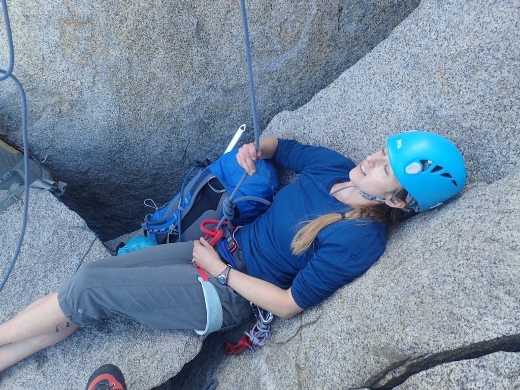 Tired climber lies on rock.