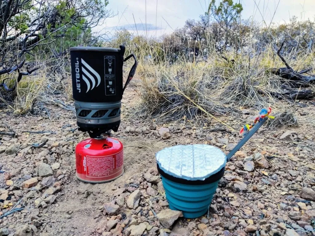 JetBoil and collapsible mug on rocky desert ground