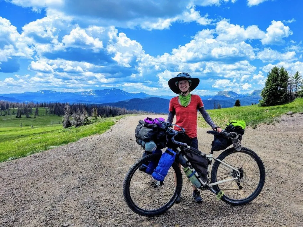 Bikepacker and bike on gravel road at Indiana Pass on Great Divide route