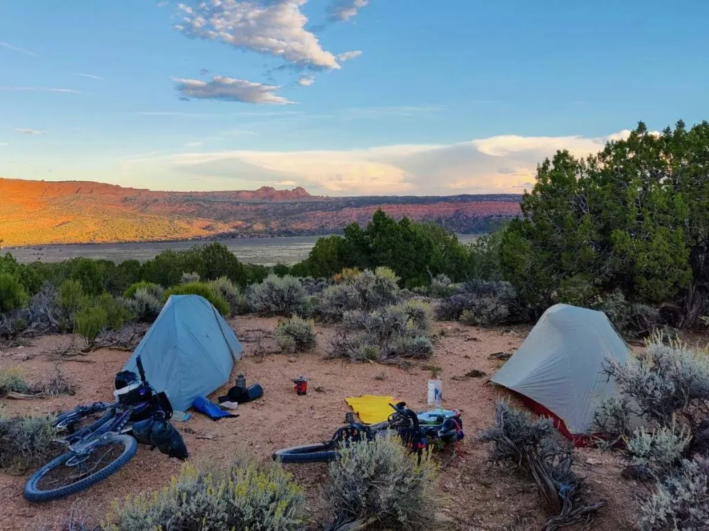 Two solo bikepacking tents pitched near each other in the Arizona desert