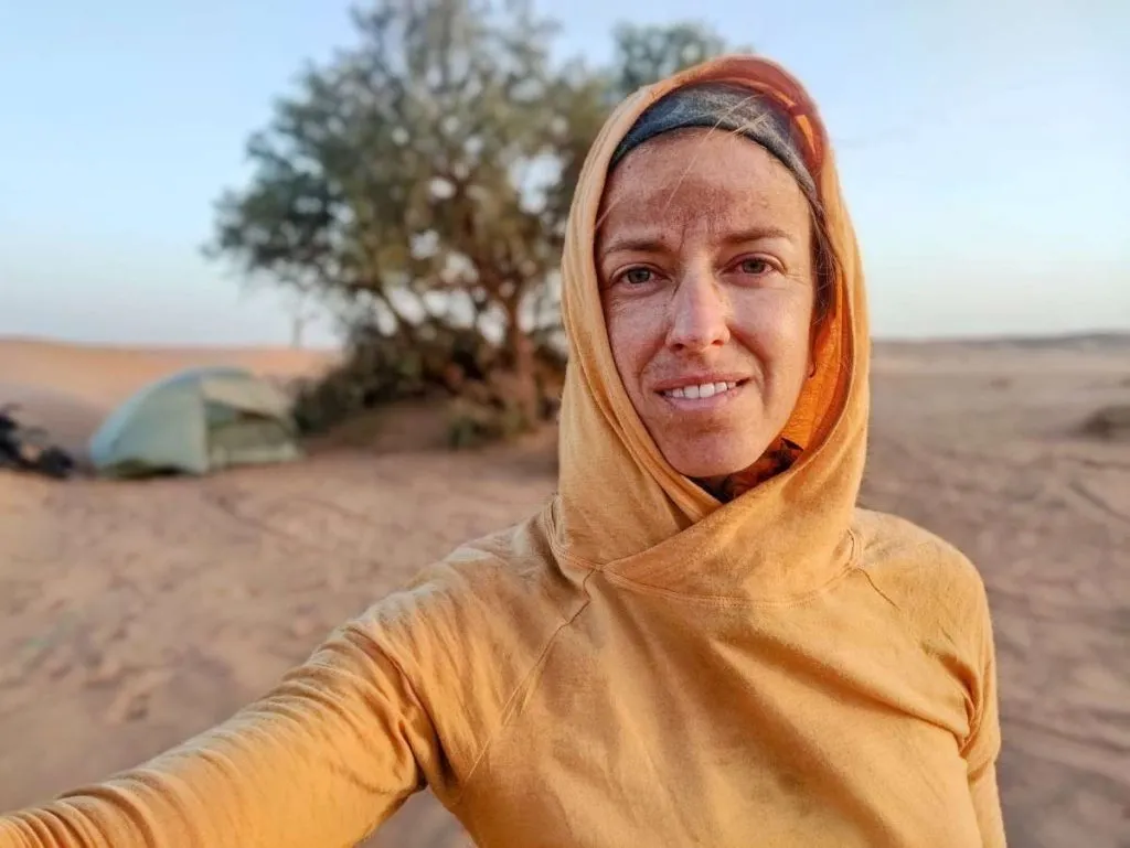Woman takes selfie in yellow Wuru sun hoody in desert of Morocco